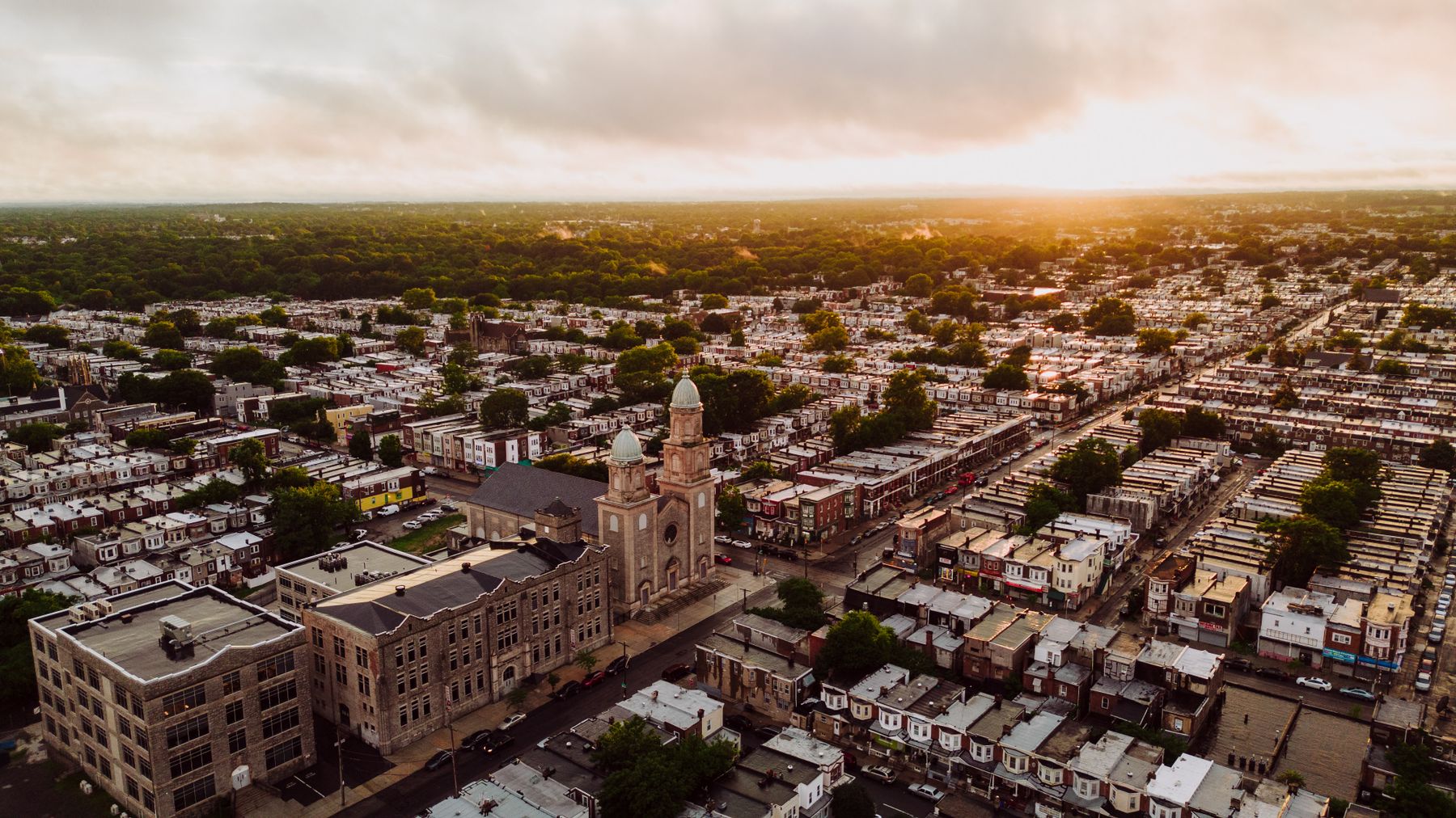 Real aerial view of Philadelphia rowhouses and a neighborhood church at sunset